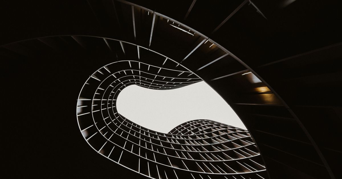 Abstract view of a modern spiral staircase in black and white highlighting architectural design.
